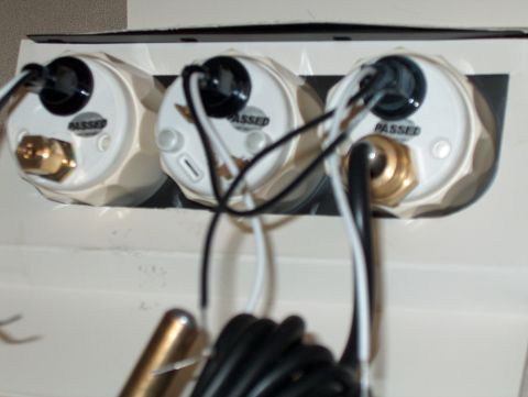 1986 Ford Bronco - Close-up of three white gauges, each marked "PASSED", with visible wiring and brass fittings.