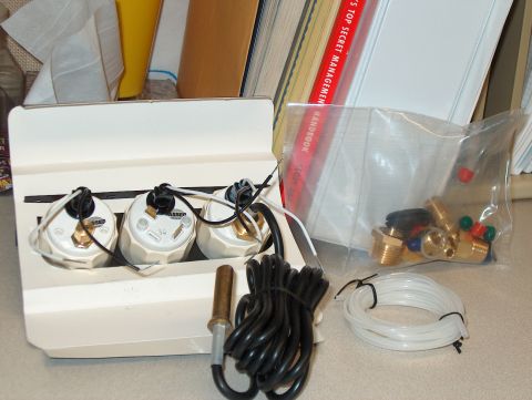 1986 Ford Bronco - A gauge cluster with three gauges and assorted fittings is shown, along with a coil of tubing and a bag of brass connectors.