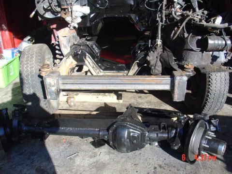 1991 Ford F-150 - Chassis of a Ford truck with its front differential removed, showing the frame and suspension components.
