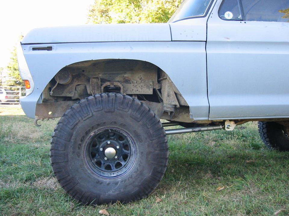 Light blue pickup truck front fender and wheel, lifted suspension