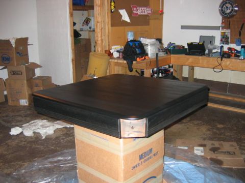 1985 Ford LTD Crown Victoria - A black table top is placed on a box in a cluttered garage setting.