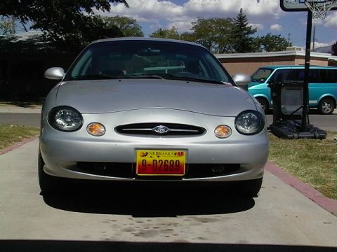 1999 Ford Taurus - Front view of a silver 1999 Ford Taurus, its distinctive grille and headlights, with a Nebraska license plate visible.
