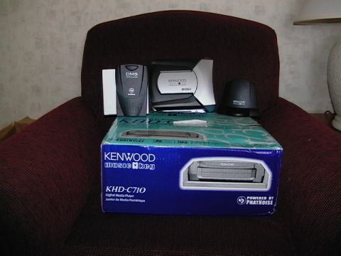 1999 Ford Taurus - Kenwood car stereo equipment is displayed on a chair, including a digital media player and other accessories.