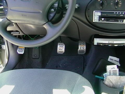 1999 Ford Taurus - Interior view of a car's dashboard and pedals, with a Wal-Mart receipt in the center console.