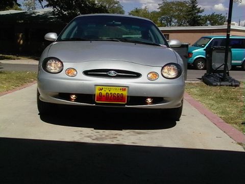 1999 Ford Taurus - Front view of a silver 1999 Ford Taurus, its distinctive oval grille and headlights.