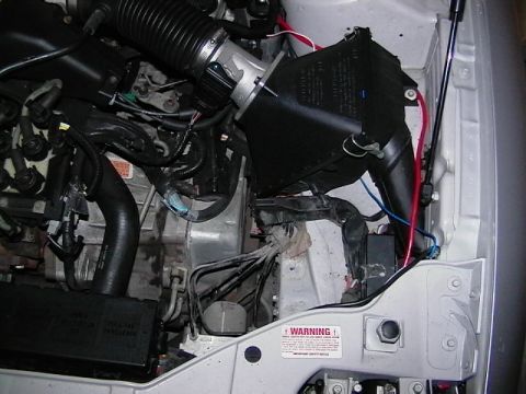 1999 Ford Taurus - Close-up of a car's engine bay, focusing on the air intake system and electrical components.