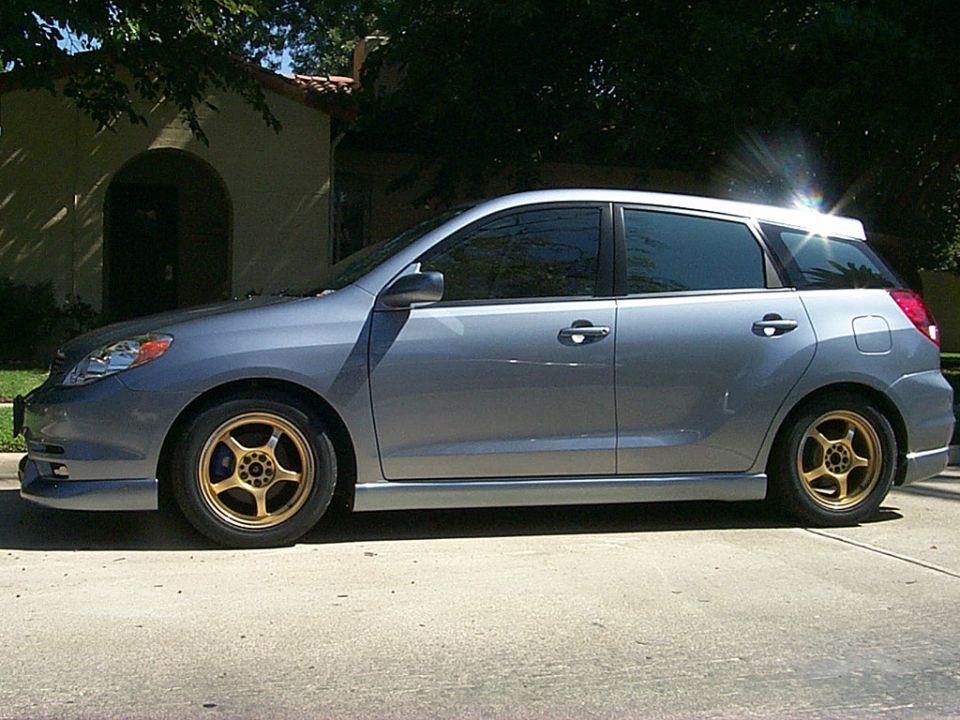 Side view of light blue-gray Toyota Matrix hatchback, lowered, with bronze five-spoke wheels