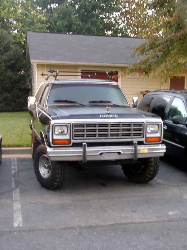 Black lifted Dodge SUV, front view, chrome grille and big off-road tires