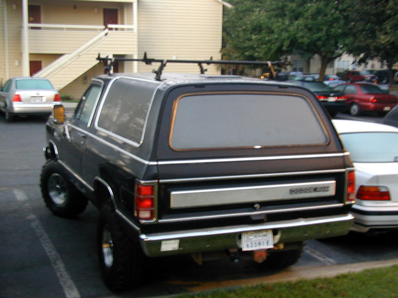 Black lifted Dodge Ramcharger SUV, rear view, in a parking lot