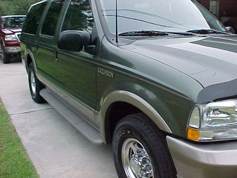 2003 Ford Excursion - A green Ford Excursion is parked next to a red Ford F-150. The Excursion has running boards and a hood protector.