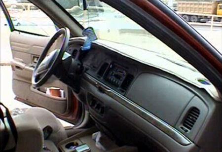 2000 Ford Crown Victoria - The interior of a 2000 Ford Crown Victoria shows the dashboard, steering wheel, and driver's side door panel.