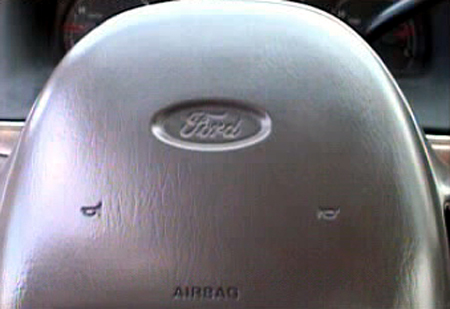 2000 Ford Crown Victoria - Interior view of a 2000 Ford Crown Victoria steering wheel, showing the Ford logo and airbag indicator.