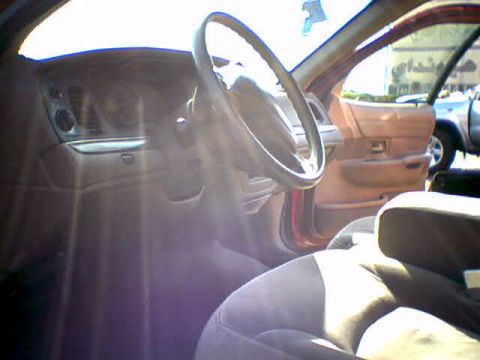2000 Ford Crown Victoria - The interior of a 2000 Ford Crown Victoria is visible, the dashboard and steering wheel.
