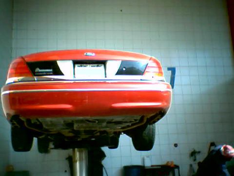 2000 Ford Crown Victoria - Rear view of a red 2000 Ford Crown Victoria being serviced on a lift.