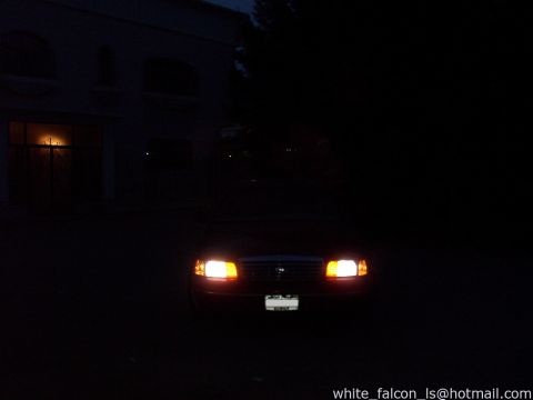 2000 Ford Crown Victoria - A 2000 Ford Crown Victoria is seen from the front at night, its headlights illuminated.