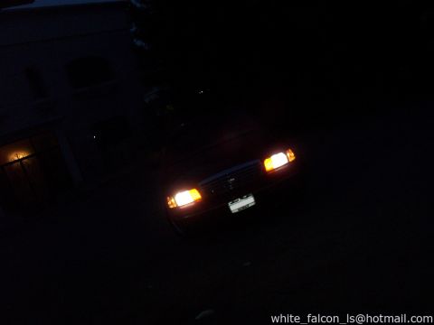 2000 Ford Crown Victoria - Front view of a 2000 Ford Crown Victoria at night, headlights illuminated.