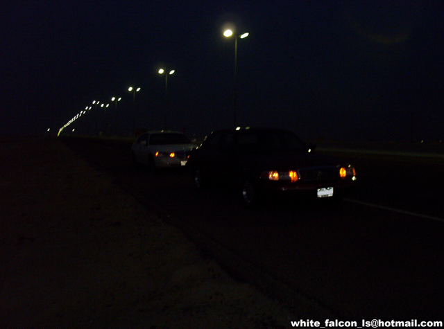 Front view of a 2000 Ford Crown Victoria at night, with another car behind it