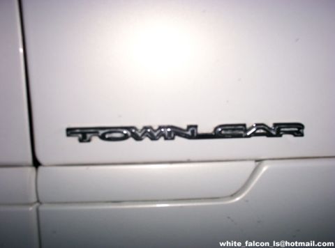 2000 Ford Crown Victoria - The image shows a close-up of the 'TOWN CAR' badge on the side of a white vehicle.
