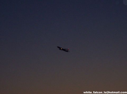 2000 Ford Crown Victoria - Jet airplane in flight at dusk. Watermark indicates Supermotors.net.