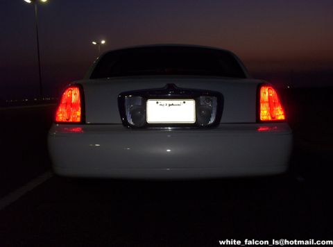 2000 Ford Crown Victoria - Rear view of a white 2000 Ford Crown Victoria at dusk, showing its distinctive taillights and license plate.