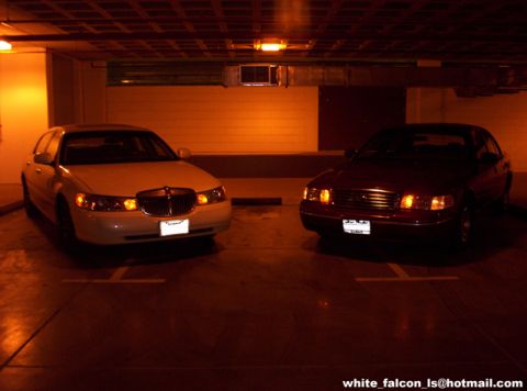 2000 Ford Crown Victoria - A white Lincoln Town Car and a dark Ford Crown Victoria are parked side-by-side in a garage.