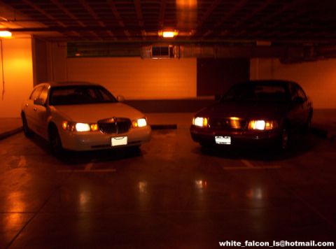 2000 Ford Crown Victoria - Two sedans, one a 2000 Ford Crown Victoria, are parked side-by-side in a parking garage.