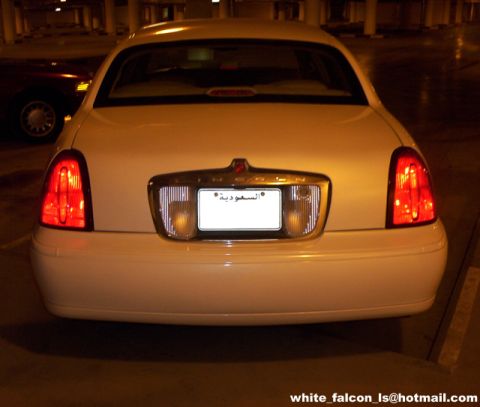 2000 Ford Crown Victoria - Rear view of a white 2000 Ford Crown Victoria parked in a garage with another vehicle nearby.