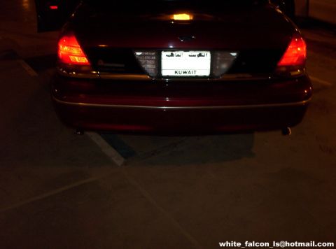 2000 Ford Crown Victoria - The rear of a red 2000 Ford Crown Victoria is visible, displaying a Kuwaiti license plate.