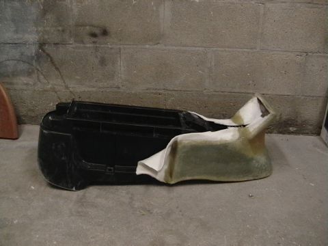 1999 Ford Taurus - Modified car bumper with fiberglass, resting on a concrete floor against a cinder block wall.