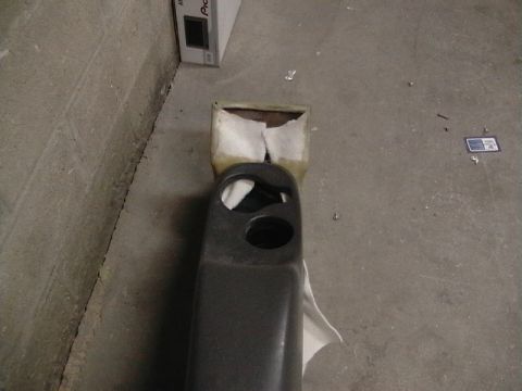 1999 Ford Taurus - A dark gray car interior part with two circular openings is shown against a concrete background.