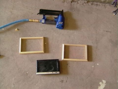 1999 Ford Taurus - Tools and materials laid out on a concrete surface, including a staple gun, frames, and a small screen.