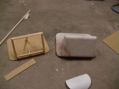 1999 Ford Taurus - A car interior part and a wooden frame are on a concrete floor with some other materials.