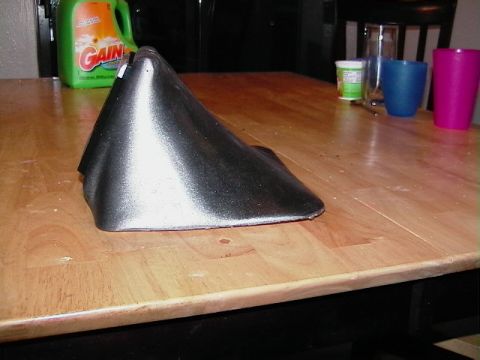 1999 Ford Taurus - A black plastic automotive part is shown on a wooden table, with household items visible in the background.