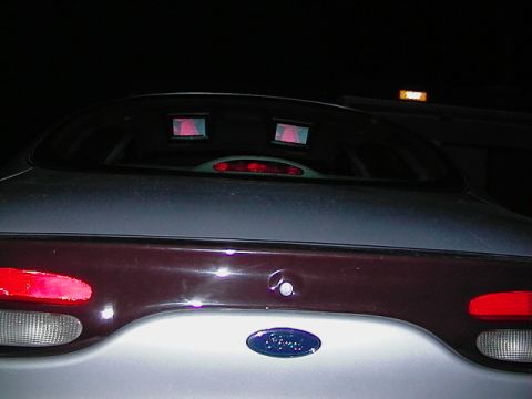 1999 Ford Taurus - The rear of a 1999 Ford Taurus is shown at night, with unusual red lights in the back window.