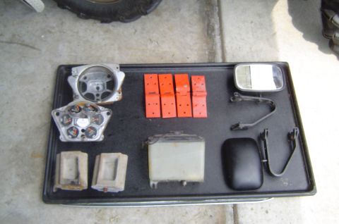 1993 Ford Bronco - Various vehicle parts are laid out on a tray, including a gauge cluster and side mirrors.