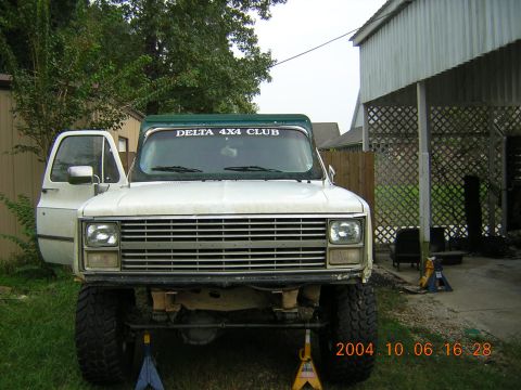 1984 Chevrolet Blazer - Front view of a lifted pickup truck with its door open, jack stands supporting the frame.