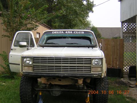 1984 Chevrolet Blazer - This lifted pickup truck is parked outside with its driver's door ajar and a club sticker on the windshield.