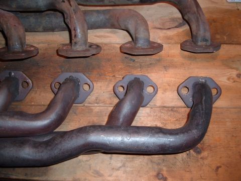 1986 Ford Bronco - Close-up of exhaust manifolds, showing their metallic tubes and mounting flanges.