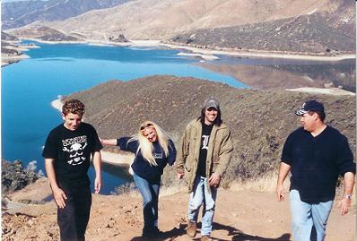 1988 Ford Bronco - A group of four people are walking down a hill with a scenic view of a lake and mountains.