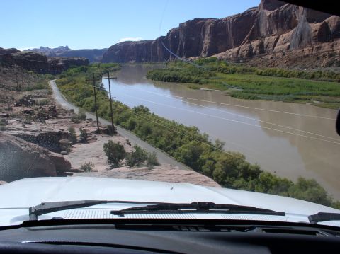 1993 Ford Bronco - Driving through a scenic desert canyon next to a wide river under a clear blue sky.