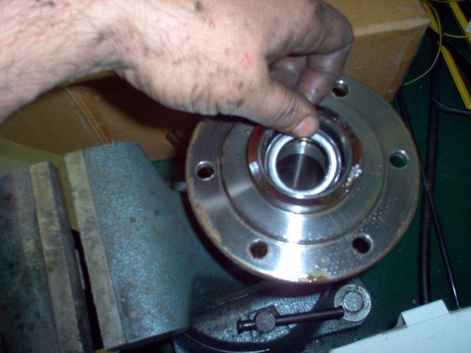 The new seal can be pushed in by hand, or with a drift.  The metal ring faces up.