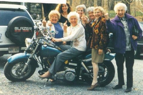 1995 Ford Bronco - Group of women posing with a motorcycle and a white SUV in the background.