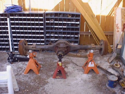 1988 Ford Bronco - Rear axle assembly supported by jack stands in a workshop setting.