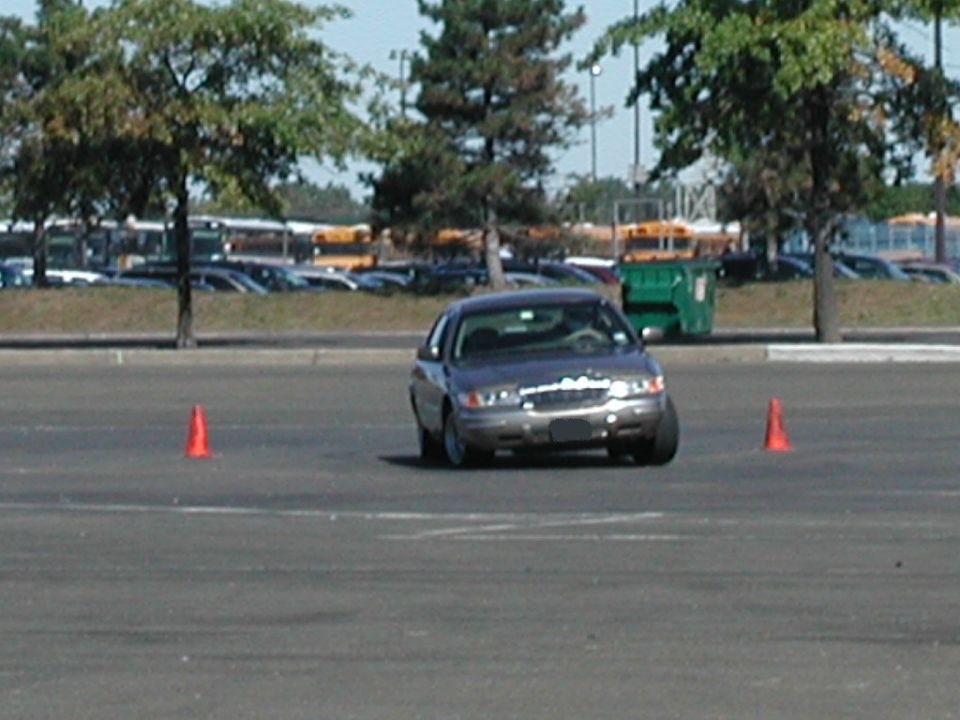 Gray 2001 Mercury Grand Marquis driving around orange cones in a parking lot