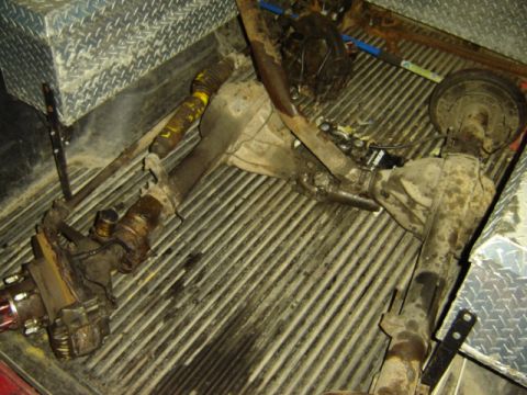 1992 Ford Bronco - Two Ford Bronco axles are visible in the bed of a truck, along with a toolbox.