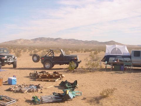1988 Ford Bronco - Desert campsite with Jeeps and a pickup truck a rooftop tent setup.