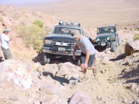 1988 Ford Bronco - A 1988 Ford Bronco navigates a challenging rocky trail, with a Jeep following closely behind.
