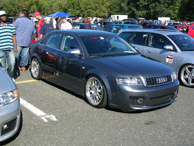 Dark gray Audi sedan with custom wheels parked at an outdoor event
