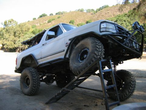 1985 Ford Bronco - This modified SUV, likely a 1987 Ford Bronco, is positioned on a ramp, its off-road capabilities.