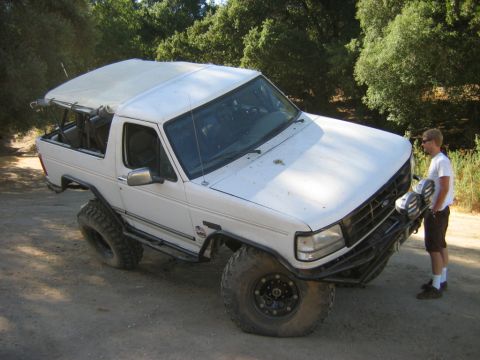1985 Ford Bronco - Modified white Ford Bronco with off-road tires and a custom front bumper.